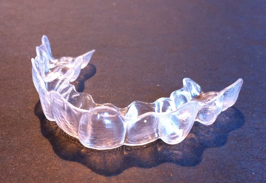 Invisalign clear aligner in hand